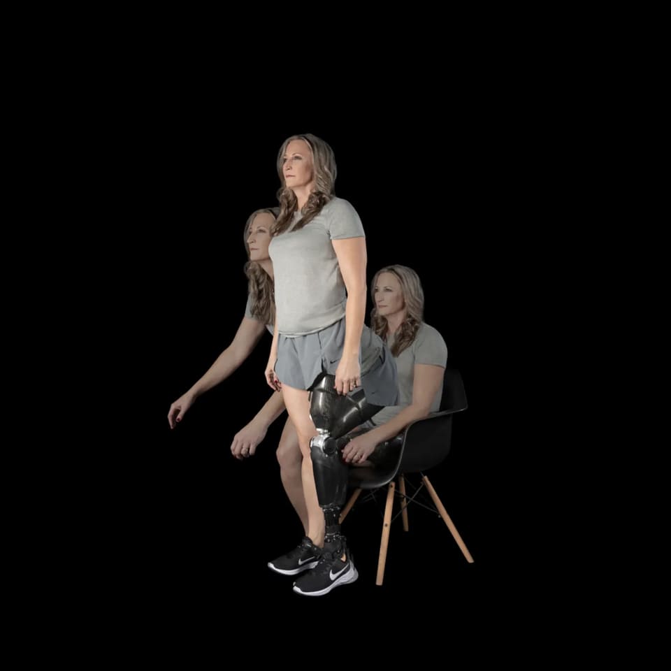 Χρήστρια μηριαίας πρόθεσης με Power Knee της Össur σηκώνεται από καρέκλα και περπατά